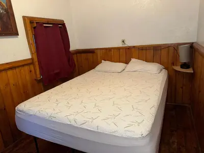 a small bed in a room with wooden walls at Big Bear Lake - Tulip Lane Cabin #25 in Big Bear Lake