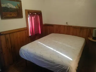 a bedroom with a white bed with a window at Big Bear Lake - Tulip Lane Cabin #25 in Big Bear Lake