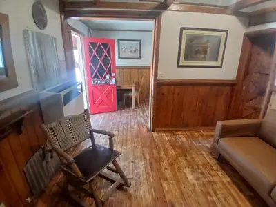 a room with a chair and a red door at Big Bear Lake - Tulip Lane Cabin #25 in Big Bear Lake