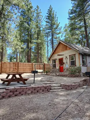 a house with a picnic table in front of it at Big Bear Lake - Tulip Lane Cabin #26 in Big Bear Lake
