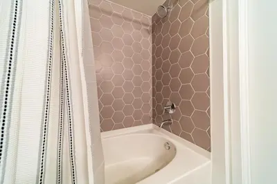 a bathroom with a white tub and a shower curtain at Sunset Blvd Studio Apt in the Heart of Hollywood in Los Angeles