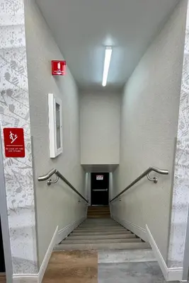 a hallway with stairs and a sign on the wall at Hotel Rudra - Hollywood in Los Angeles