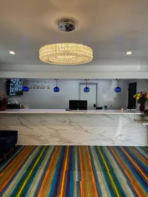 a lobby with a reception desk and a chandelier at Hotel Rudra - Hollywood in Los Angeles