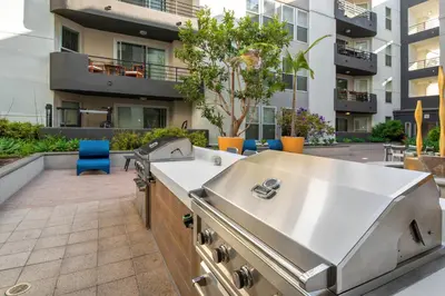 a barbecue on a patio with a building in the background at Cozy Oasis in Marina Del Rey!Free Swimming Pool and Parking in Los Angeles