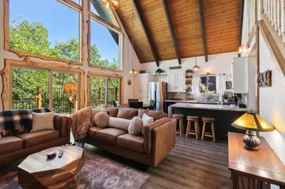 a living room with a couch and a kitchen at Timeless Traditions Arrowhead home in Lake Arrowhead