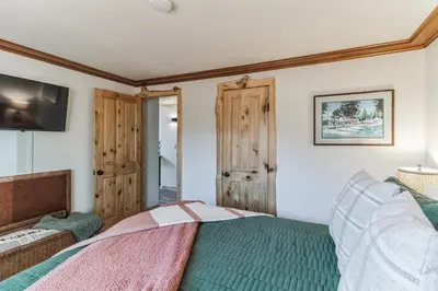 a bedroom with a bed and a tv on a wall at Timeless Traditions Arrowhead home in Lake Arrowhead