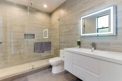 a bathroom with a toilet and a sink and a mirror at Modern 4 Bedroom Masterpiece With Rooftop Deck in Los Angeles