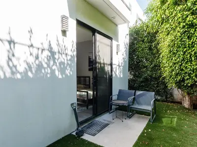 a patio with two chairs and a table next to a building at Modern 4 Bedroom Masterpiece With Rooftop Deck in Los Angeles