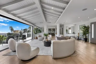 a living room with white furniture and large windows at Maravilla in Los Angeles