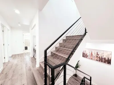 a staircase in a home with white walls and wooden floors at Cozy 3 BR Townhouse with Balcony in Los Angeles