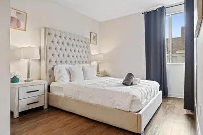 a bedroom with a large bed with a cat sitting on it at Le Reve , 5 min to the beach Luxury Condo in Los Angeles