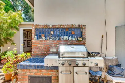 an outdoor kitchen with a brick wall with a stove at Vibrant Home with Patio - Near Santa Monica Pier! in Los Angeles
