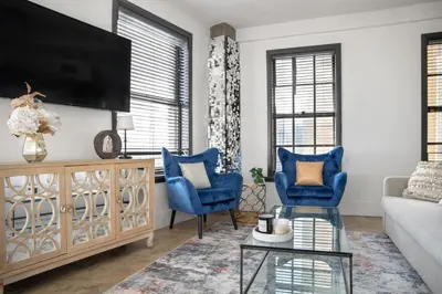 a living room with blue chairs and a tv at Bright lights central Downtown in Los Angeles
