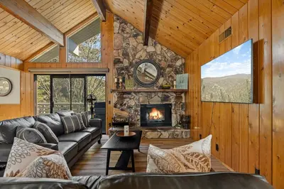 a living room with a couch and a fireplace at Pine Oaks Cabin in Lake Arrowhead