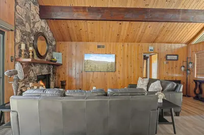 a living room with a couch and a fireplace at Pine Oaks Cabin in Lake Arrowhead