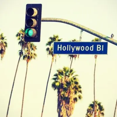 a traffic light with a street sign and palm trees at Hollywood Townhome, Resort Amenities, 2 Free Parking Spaces! in Los Angeles