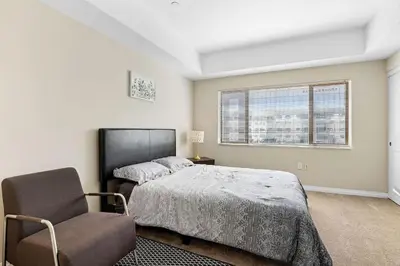 a bedroom with a bed and a chair and a window at Charming 2BR2BA Home Near Downtown LA And Walkable Amenities in Monterey Park
