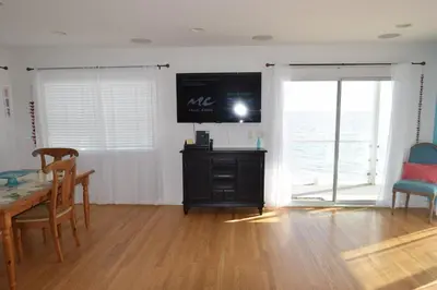 a living room with a table and a screen at Malibu Private Beach Apartments in Malibu