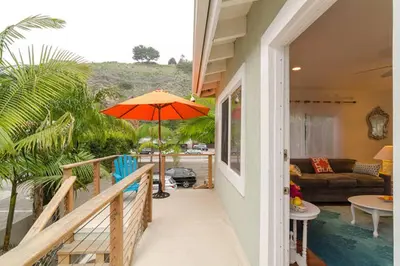 a balcony with an orange umbrella on a house at Malibu Private Beach Apartments in Malibu