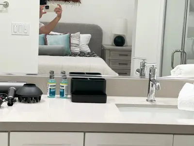 a person taking a picture of a bathroom with a mirror at \u6d1b\u6749\u77f6\u5b89\u5927\u7565\u6e29\u6c34\u6cf3\u6c60\u4e09\u623f\u522b\u5885 in Ontario