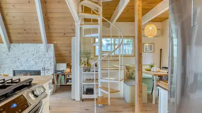 a kitchen with a spiral staircase in a house at A-Frame Retreat Chic and Modern Forest Views Hammock Outdoor Dining Decks in Lake Arrowhead