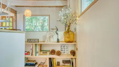 a book shelf with books and a vase on it at A-Frame Retreat Chic and Modern Forest Views Hammock Outdoor Dining Decks in Lake Arrowhead