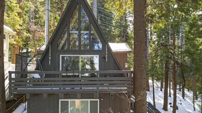 a tree house with a porch and windows at A-Frame Retreat Chic and Modern Forest Views Hammock Outdoor Dining Decks in Lake Arrowhead