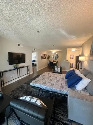 a living room with a large bed with blue pillows at Exceptional 2 BR in Heart of Hollywood 201 in Los Angeles