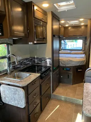 an rv kitchen with a sink and a bed at AJ-XL RV Rental in Reseda