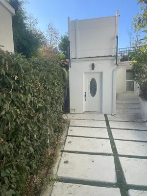 a white building with a white door and stairs at UCLA Thurston in Los Angeles