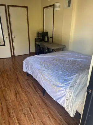 a bedroom with a bed and a desk and a table at UCLA Thurston in Los Angeles