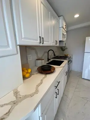 a kitchen with white cabinets and a bowl of fruit on the counter at UCLA Thurston in Los Angeles