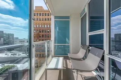 a balcony with two chairs and a table at 2 Bed 2 Bath Contemporary High Rise DTLA Living in Los Angeles