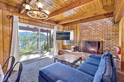a living room with a blue couch and a fireplace at Inspiration point retreat #2470 in Big Bear Lake