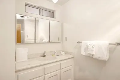 a white bathroom with a sink and a mirror at Inspiration point retreat #2470 in Big Bear Lake