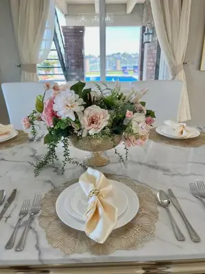 a table with plates and a vase of flowers on it at Top of the World Anaheim View Home in Anaheim