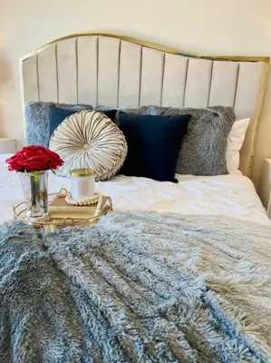 a bed with a blue and white blanket and flowers on it at Top of the World Anaheim View Home in Anaheim