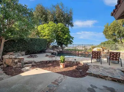 a garden with two chairs and a pool at Secluded Romantic Getaway Home in Anaheim