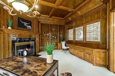 a living room with a fireplace and wooden walls at Luxury Oasis With Panoramic Views in Anaheim