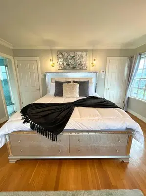 a bedroom with a large bed with white sheets and pillows at Ocean Boulevard Beachfront Home in Long Beach