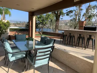 a glass table and chairs on a patio at Stunning Panoramic Waterfront Pool Home Escape in Anaheim