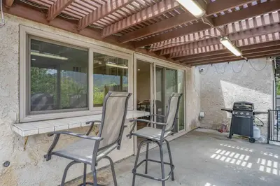 a patio with two chairs and a table and windows at Elm Mountain View Fire pit, quiet and more in Los Angeles