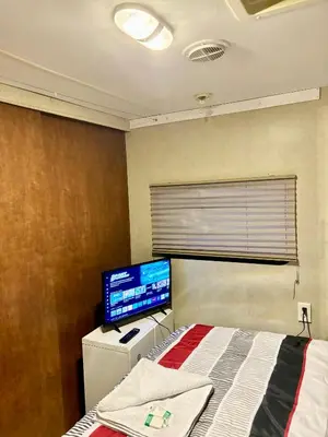 a bedroom with a bed and a flat screen tv at Rooms in Modern RV Trailer Home in Los Angeles