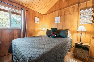 a teddy bear sitting on a bed in a bedroom at Chateau Rouge - Walk to Lake & Village, AC, Pet Friendly! in Big Bear Lake