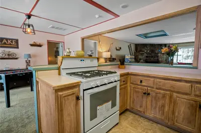 a kitchen with wooden cabinets and a stove top oven at Wanderlust - Hot Tub, Foosball, Ping Pong, Walk to Lake & Village! in Big Bear Lake