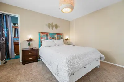 a white bedroom with a bed and a window at Wanderlust - Hot Tub, Foosball, Ping Pong, Walk to Lake & Village! in Big Bear Lake