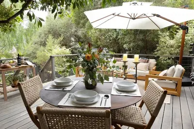 a table with chairs and an umbrella on a deck at Zen Birds Nest of Topanga Boho Chic with Epic Deck in Topanga