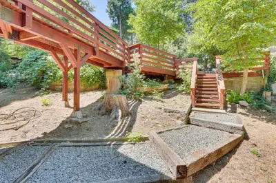 a house with a wooden structure with a staircase at 1 Mi to Lake Crestline Cabin with Deck and Gas Grill! in Crestline