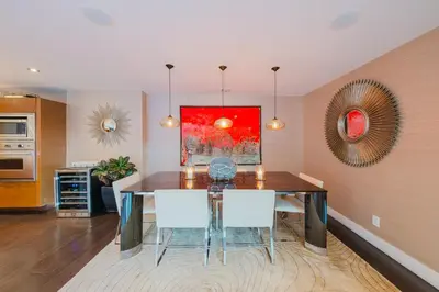 a dining room with a table and white chairs at Casa Azul in Los Angeles