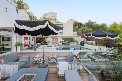 a patio with chairs and an umbrella and a pool at Casa Azul in Los Angeles